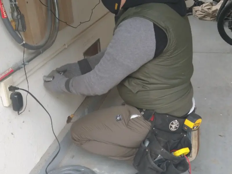 Electrician performing outlet wiring in a Cairo garage